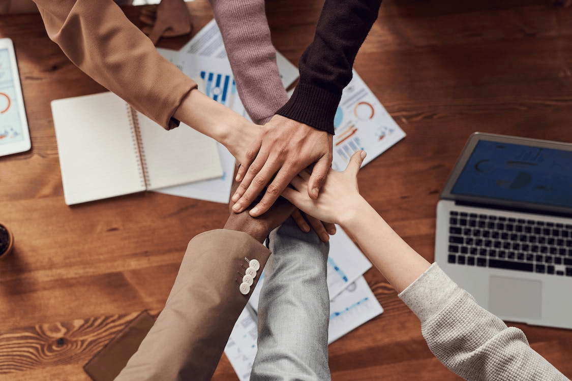 Team members putting hands together in the middle